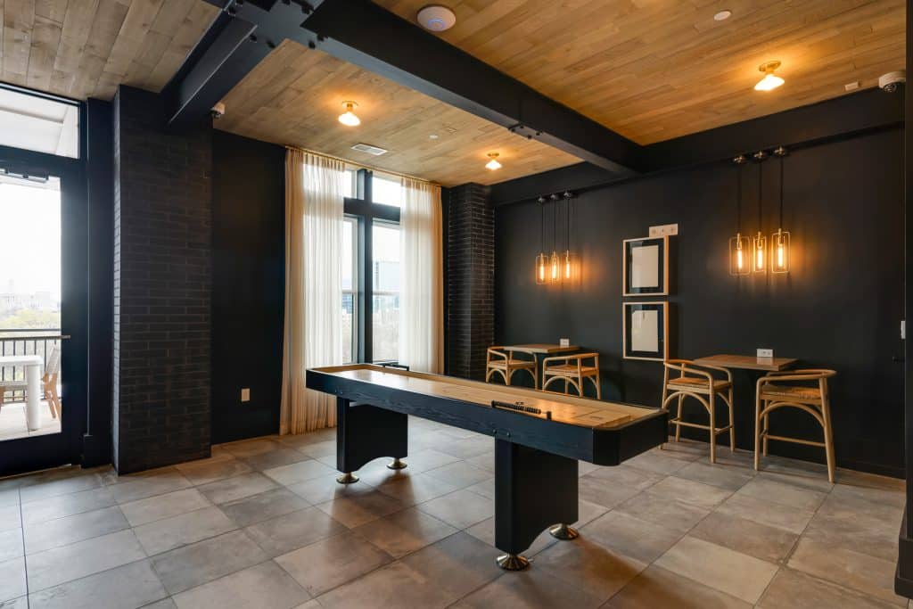Shuffleboard table and hightop table seating in Margaux Midtown's community clubroom