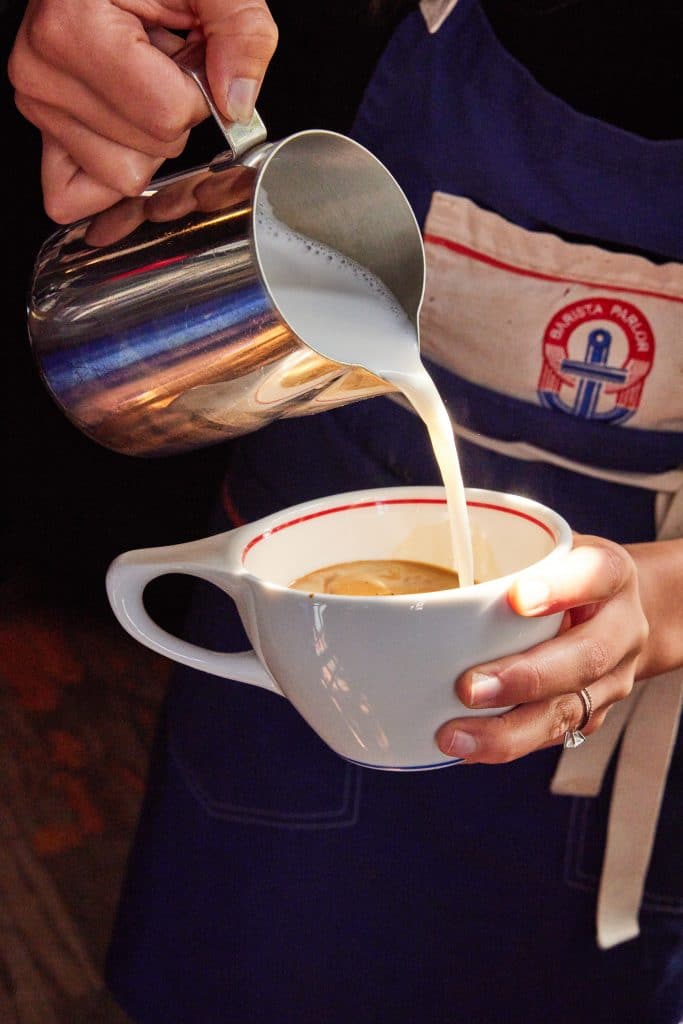 Margaux Midtown lifestyle photo of a barista making a latte